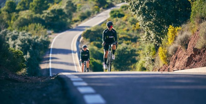 a couple of people riding bikes down a road