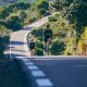 a couple of people riding bikes down a road