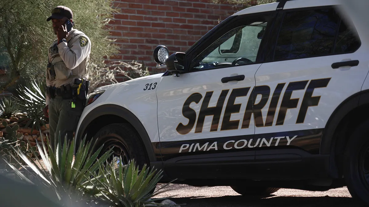 A Pima County sheriff's official standing outside Nancy Guthrie's home in Tucson