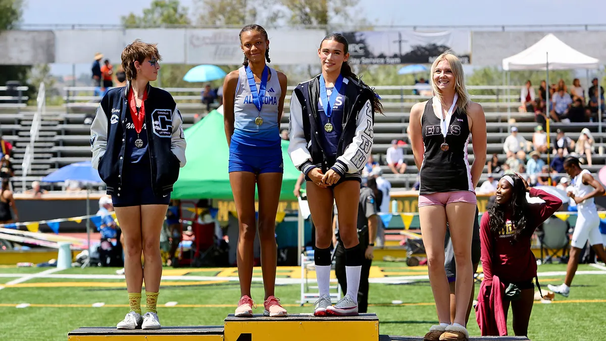 AB Hernandez standing on the high jump podium with fellow competitors at a track meet