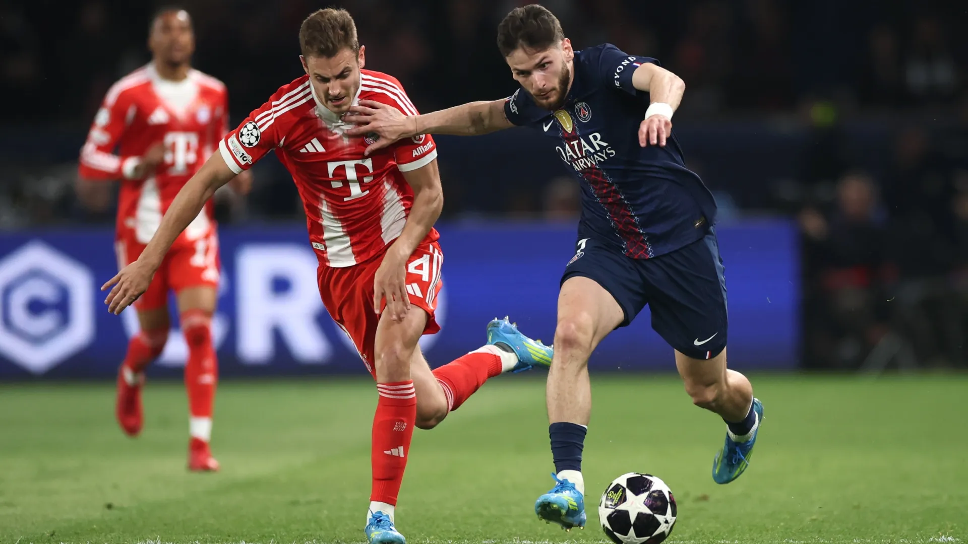 Aleksandar Pavlovic, do Bayern de Munique, é desafiado por Khvicha Kvaratskhelia, do PSG.