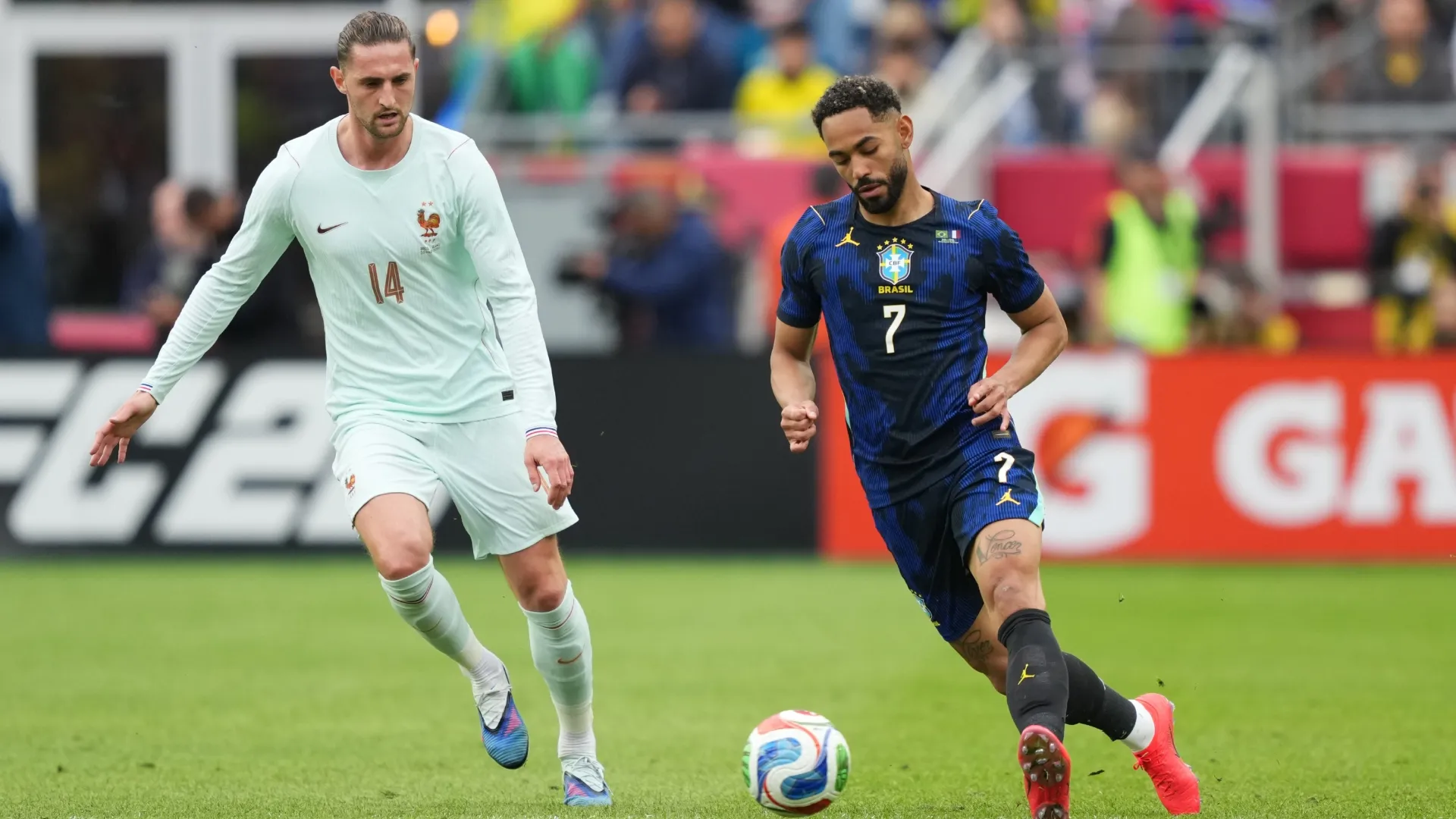Matheus Cunha, do Brasil, corre com a bola contra Adrien Rabiot, da França.