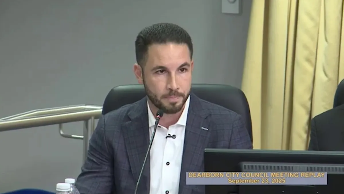Dearborn Mayor Abdullah Hammoud sitting at city council dais speaking into microphone