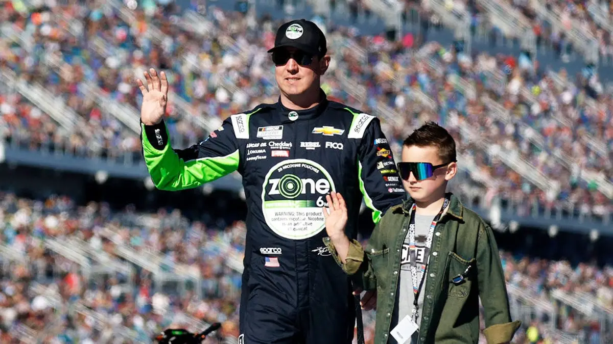 Kyle Busch and his son Brexton Busch waving to fans onstage at Daytona International Speedway