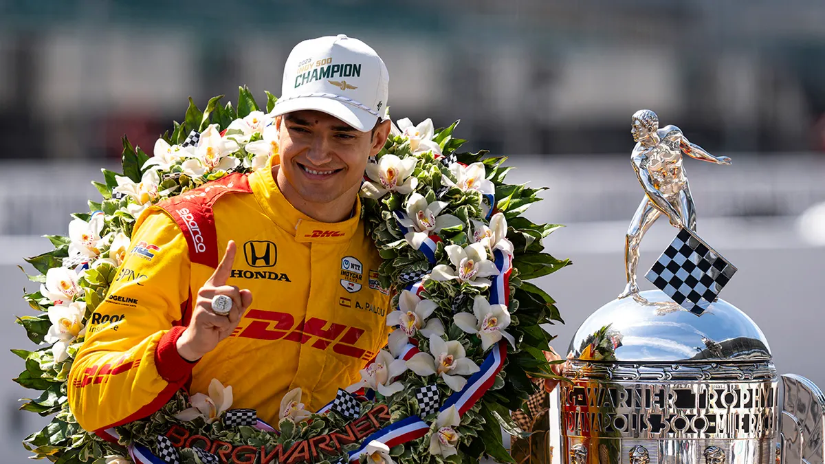 Indianapolis 500 champion Alex Palou posing with Borg-Warner Trophy at Indianapolis Motor Speedway