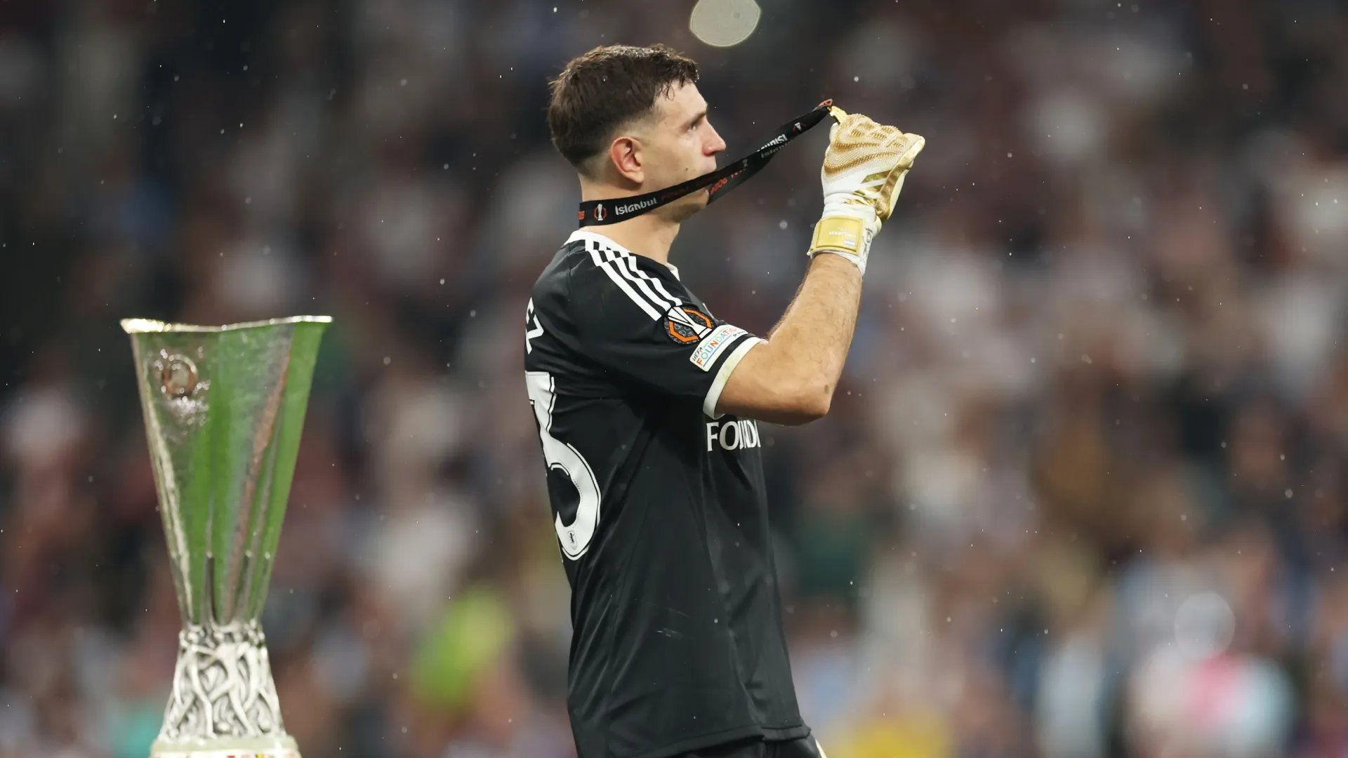 Emiliano Martinez, do Aston Villa, comemora com a medalha do vencedor ao passar pelo troféu da UEFA Europa League.