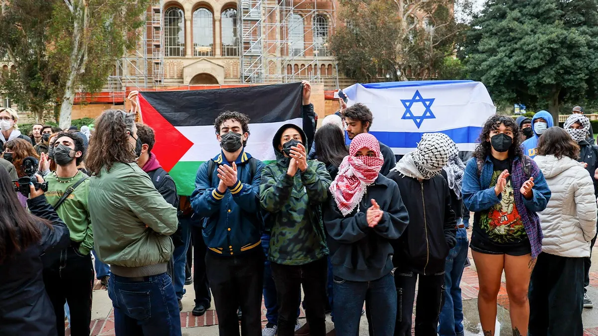 Protesters stand in front of Israeli and Palestinian flags at UCLA
