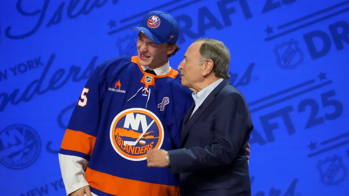 Matthew Schaefer holding a hockey jersey after being selected first overall by the New York Islanders