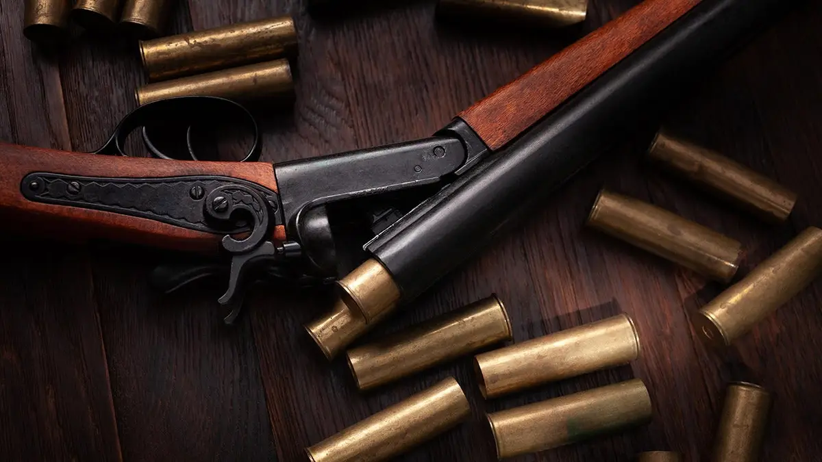 Vintage retro shotgun with brass cartridges on wooden table