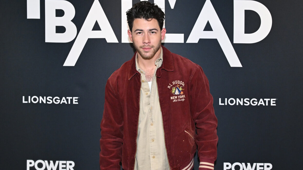 Nick Jonas vestindo uma jaqueta vermelha