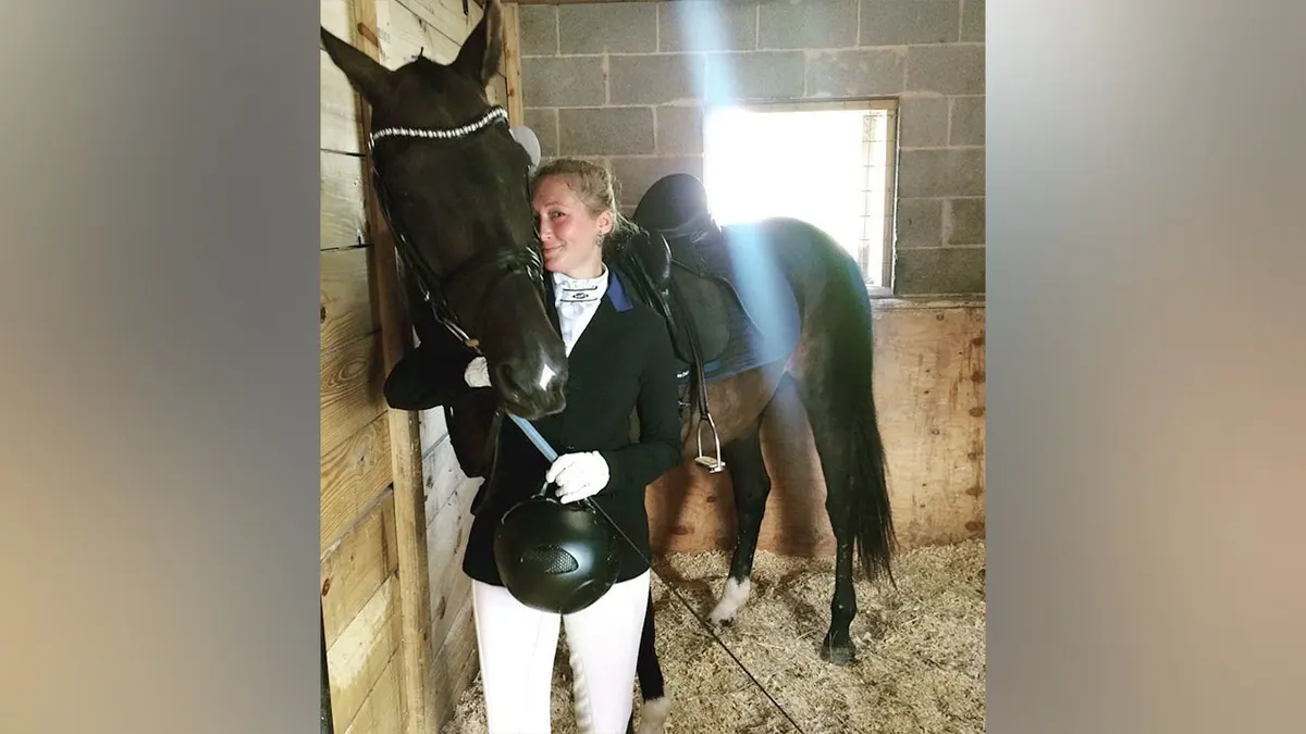 Lauren Kanarek posing next to her horse