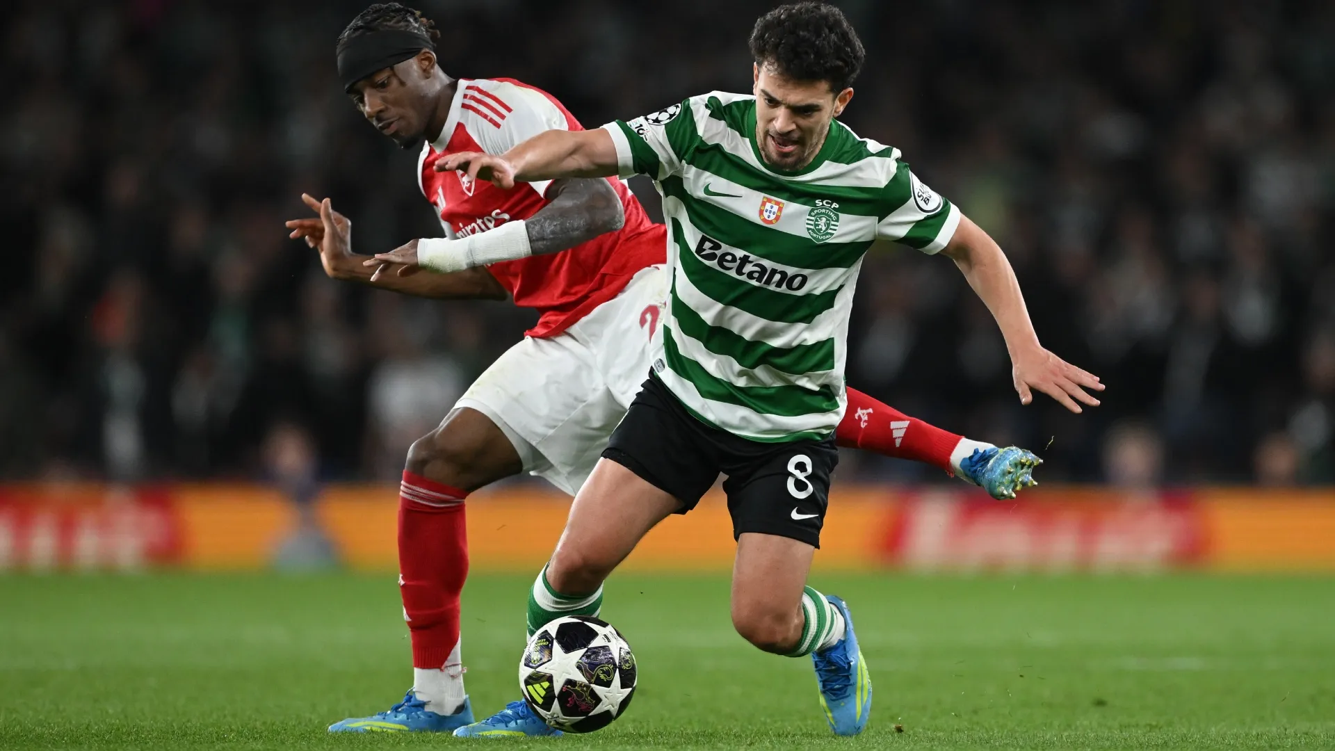 Pedro Goncalves do Sporting Clube de Portugal corre com a bola whilst sob pressão de Noni Madueke do Arsenal.