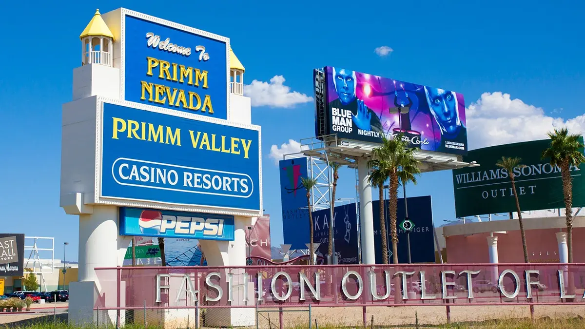 A blue sign advertising the Primm Valley Casino Resorts stands against a bright blue sky.