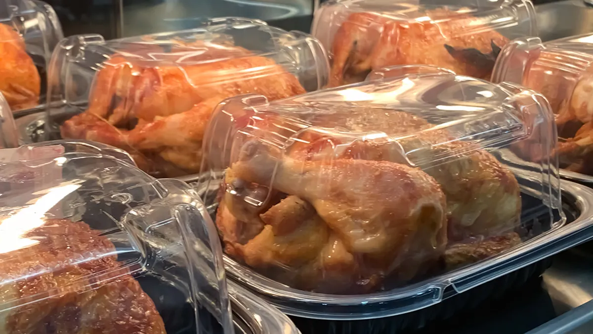 Packaged rotisserie chickens placed on supermarket deli shelf