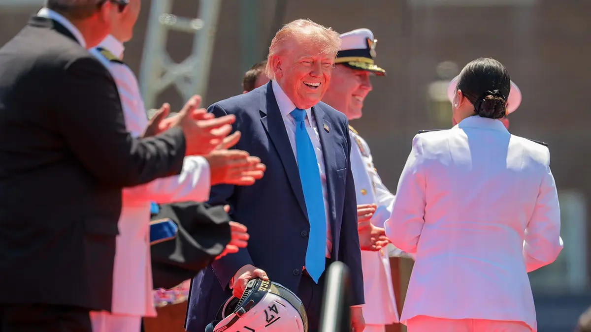 Cadet Savannah Riera presenting a football helmet to President Donald Trump at Coast Guard Academy ceremony
