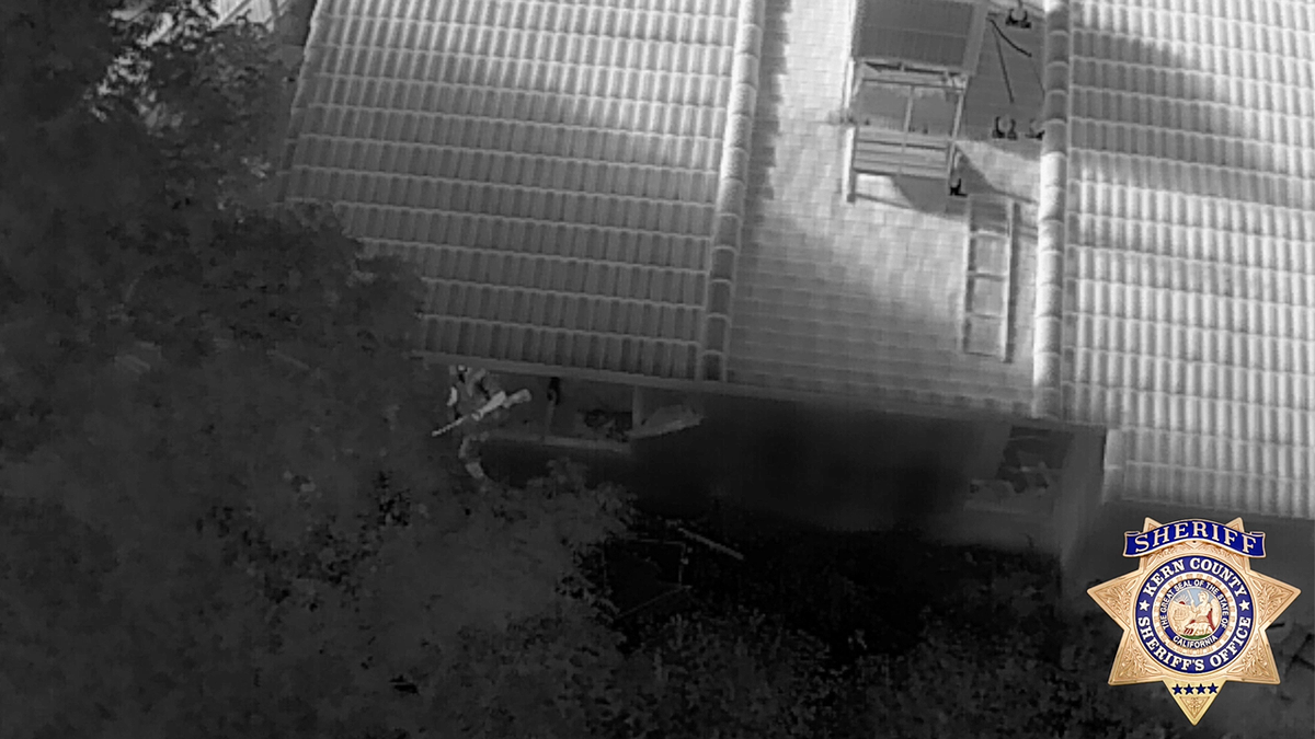 Thermal drone image shows armed suspect hiding outside Porterville home during SWAT standoff.