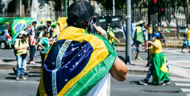 a man with a flag on his back walking down the street