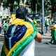 a man with a flag on his back walking down the street