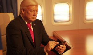 a man in a suit and tie looking at a cell phone