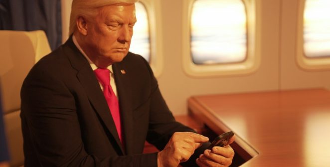 a man in a suit and tie looking at a cell phone