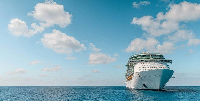 white and blue ship on sea under blue sky and white clouds during daytime