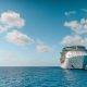 white and blue ship on sea under blue sky and white clouds during daytime