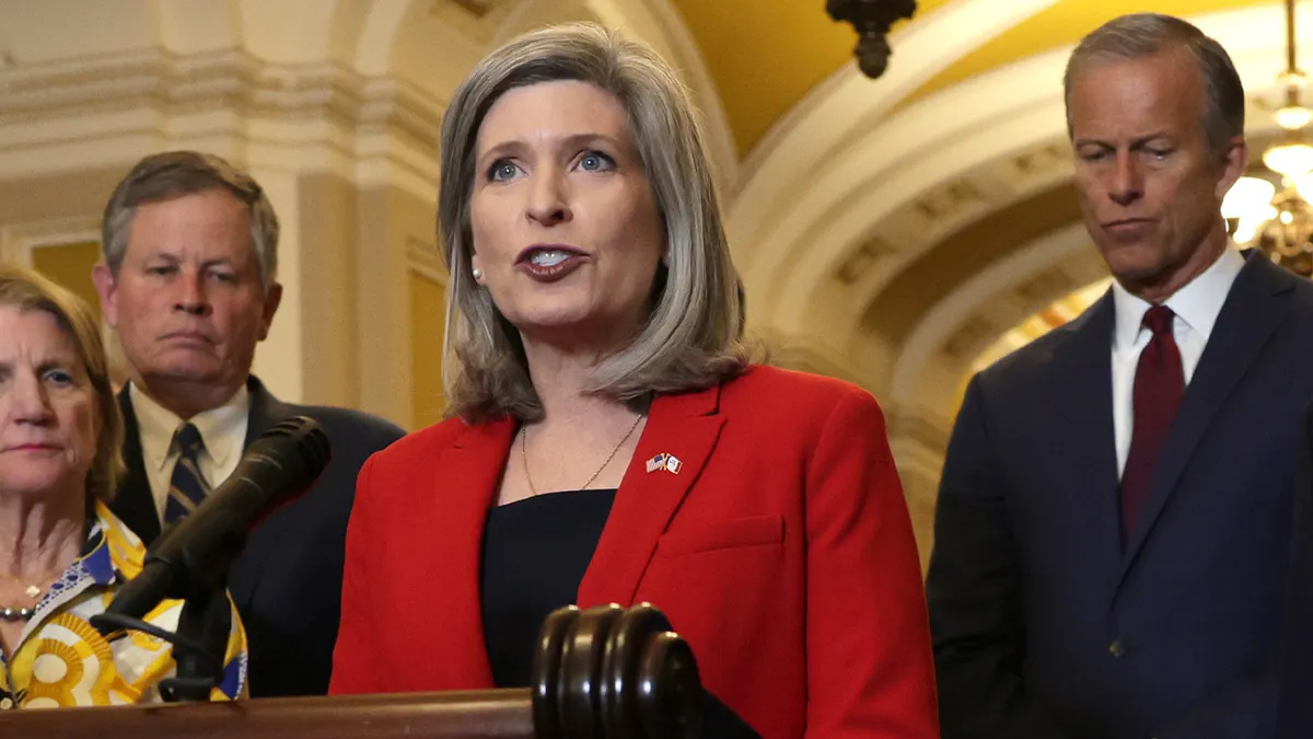 Sen. Joni Ernst speaking during a news briefing at the U.S. Capitol with other senators listening