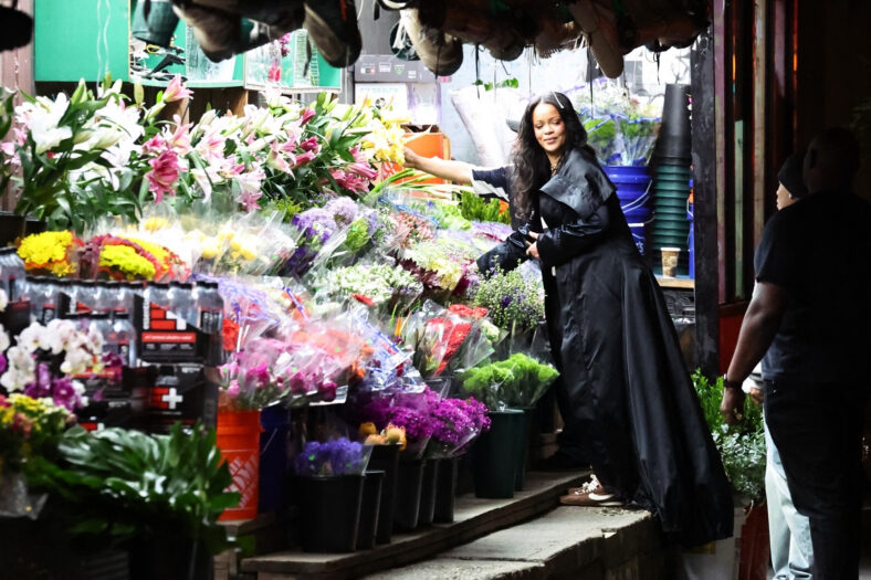 Rihanna folheia flores em estande ao ar livre