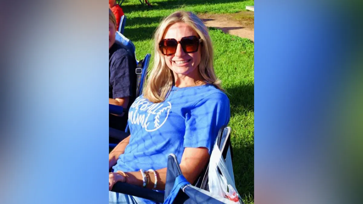 Misty Roberts standing and smiling in a portrait-style photo.