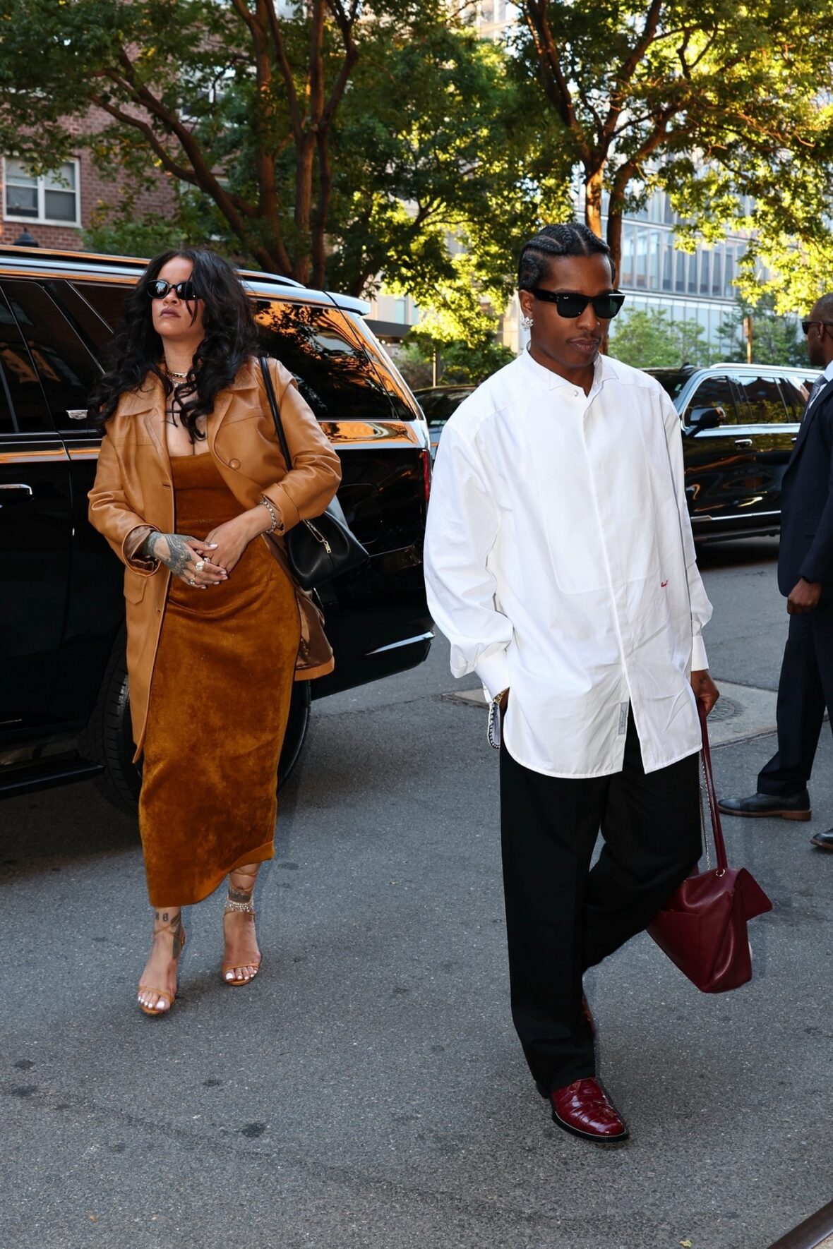 Rihanna em um vestido justo de veludo cor mostarda e A$AP Rocky em uma camisa de botão branca enquanto saem do veículo