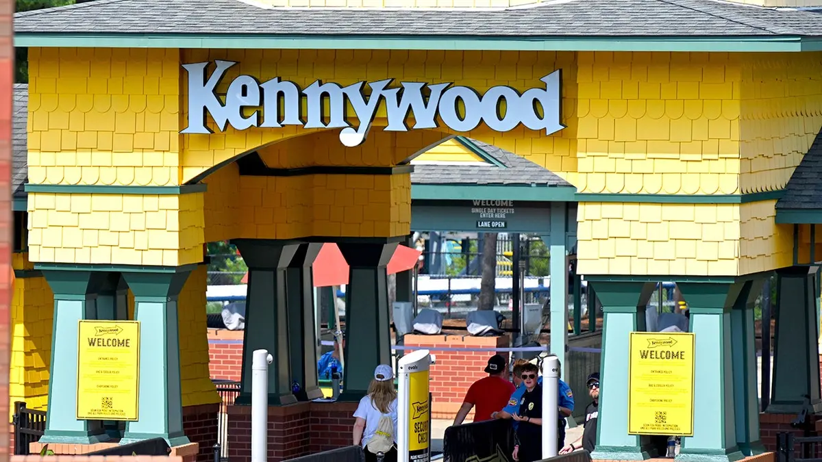 Patrons passing through security under the Kennywood sign at the main entrance to Kennywood Amusement Park