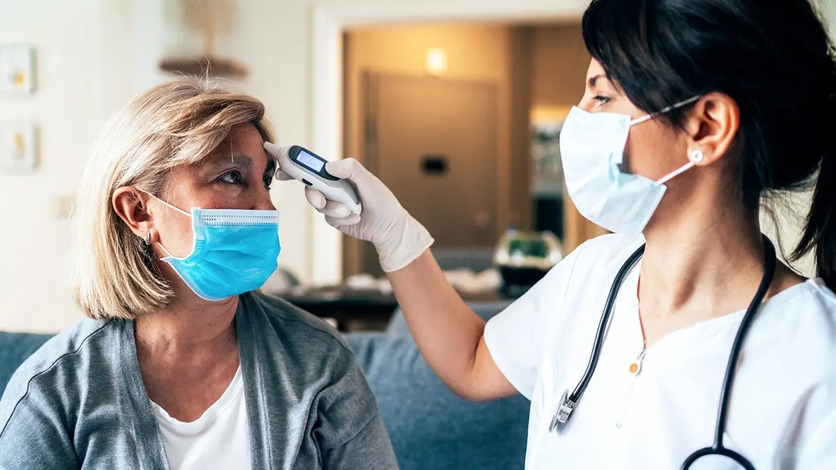 A doctor takes a woman's temperature.