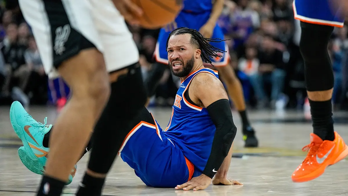 New York Knicks guard Jalen Brunson falling after a foul during a basketball game.