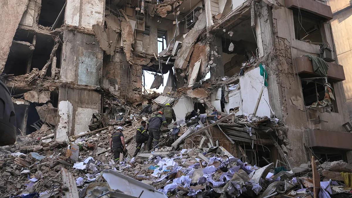 Lebanese civil defense workers searching rubble of destroyed building in Beirut