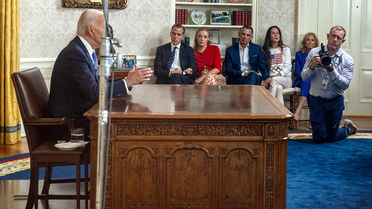 US President Joe Biden speaking in the Oval Office with family listening