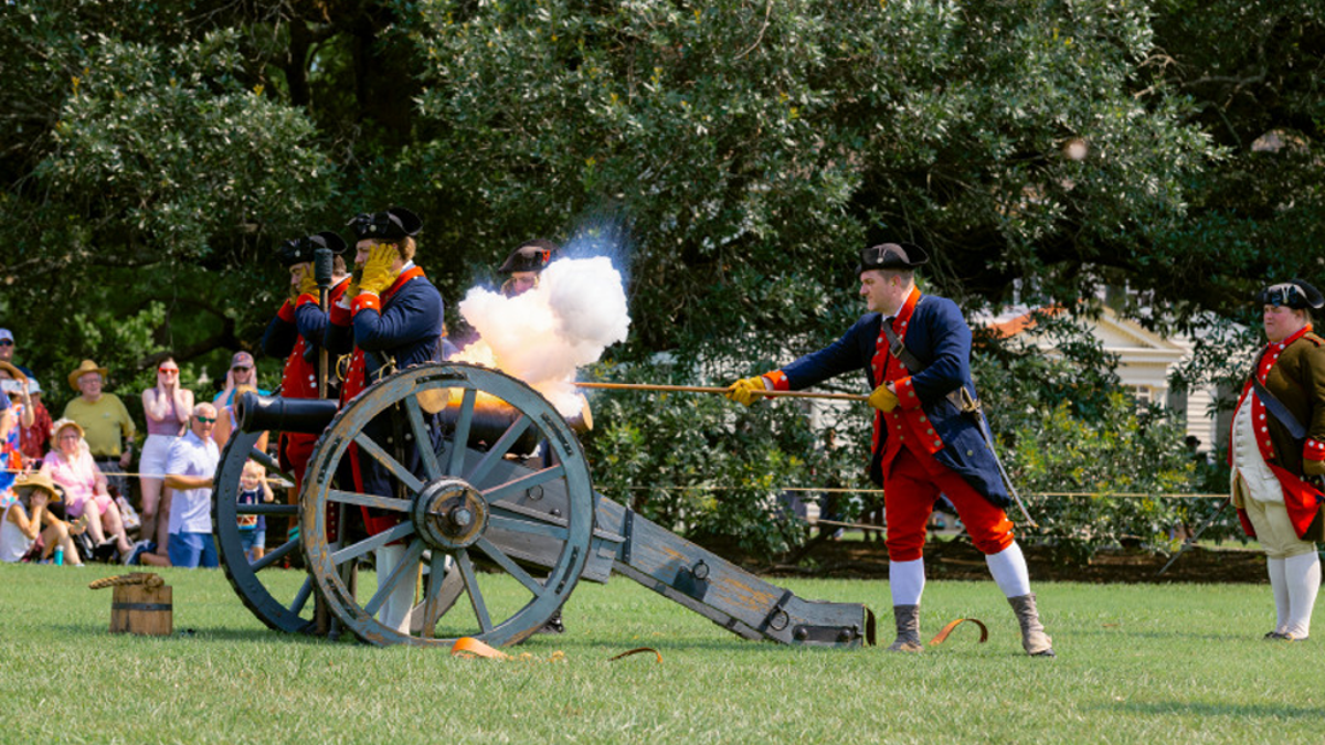 Revolutionary War interpreters fire a cannon.