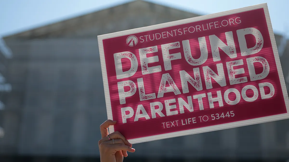 Protestors holding Defund Planned Parenthood signs outside the U.S. Supreme Court in Washington, D.C.