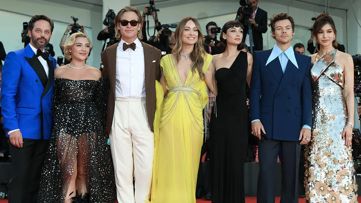 Olivia Wilde and Harry Styles standing with cast members Nick Kroll, Florence Pugh, Chris Pine, Sydney Chandler, and Gemma Chan at Venice Film Festival