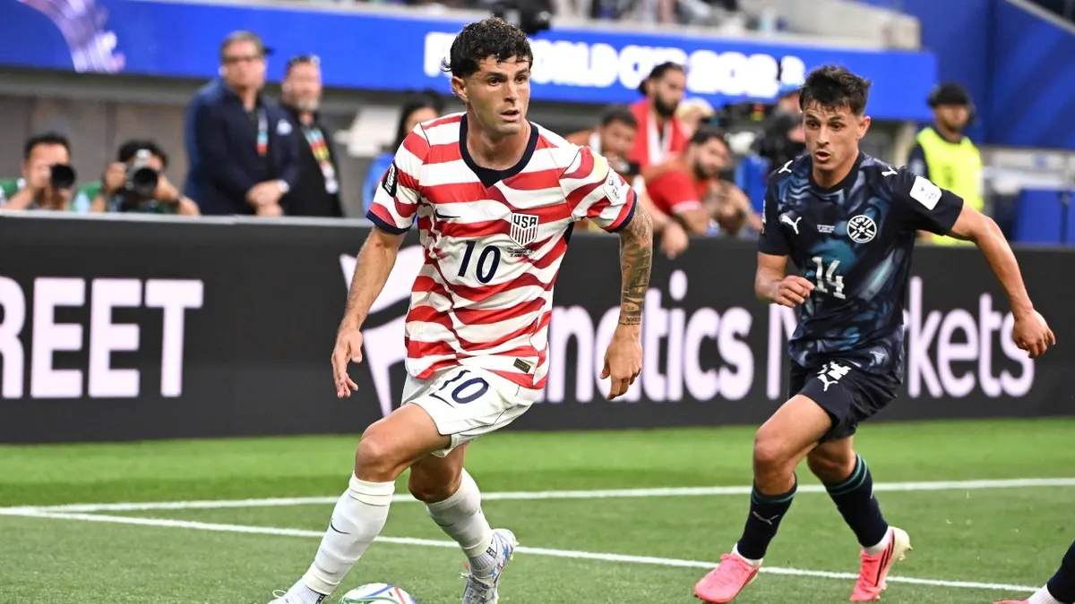 United States forward Christian Pulisic controls the ball past Paraguay midfielder Andrés Cubas in the first half of a FIFA World Cup 2026 match at SoFi Stadium in Los Angeles.