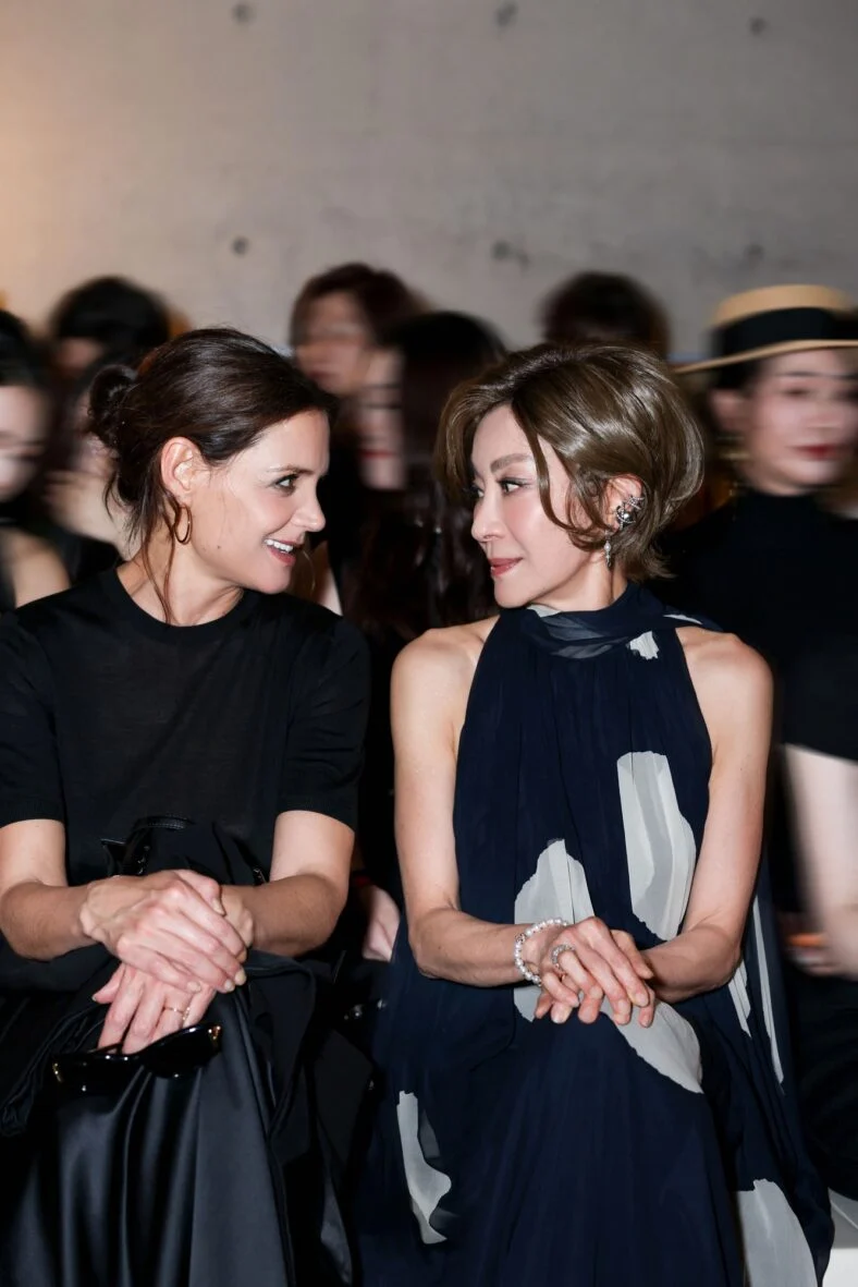 Katie Holmes e Michelle Yeoh sorriem uma para a outra enquanto sentam na primeira fila do desfile de moda Max Mara em Xangai