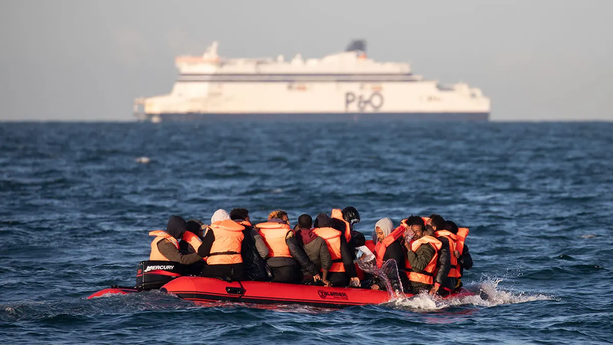 Migrants bailing water from a small inflatable boat near Dover Strait