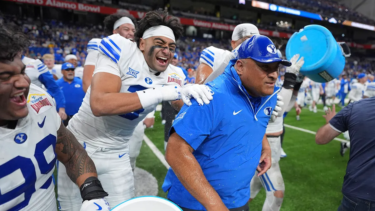 BYU head coach Kalani Sitake reacting after being doused during celebration
