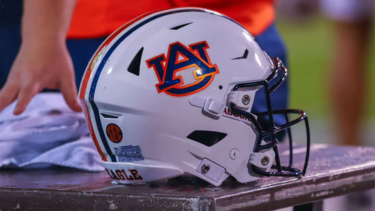 An Auburn helmet sitting on a bench at Davis Wade Stadium during a football game.