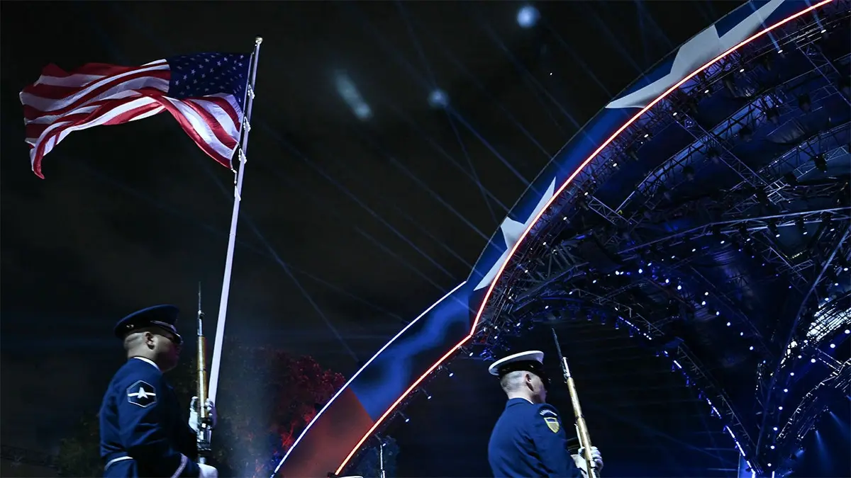 A U.S. service member stands while holding an American flag