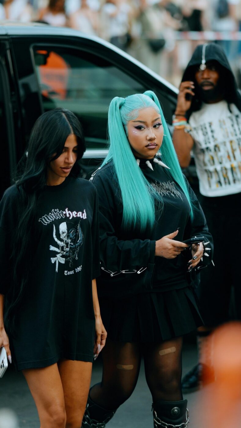 North West usa roupa grunge preta com longos cabelos azuis presos em tranças altas.