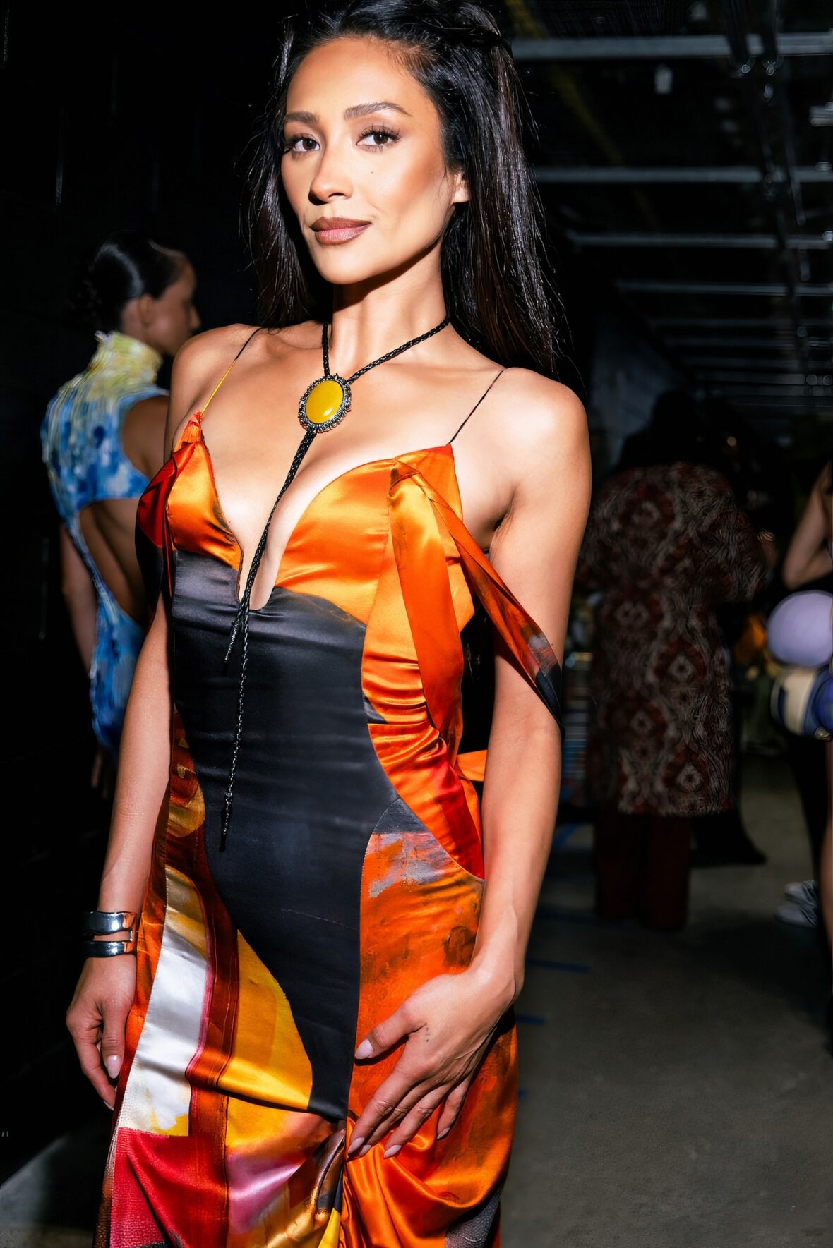 Shay Mitchell em um vestido laranja nos bastidores