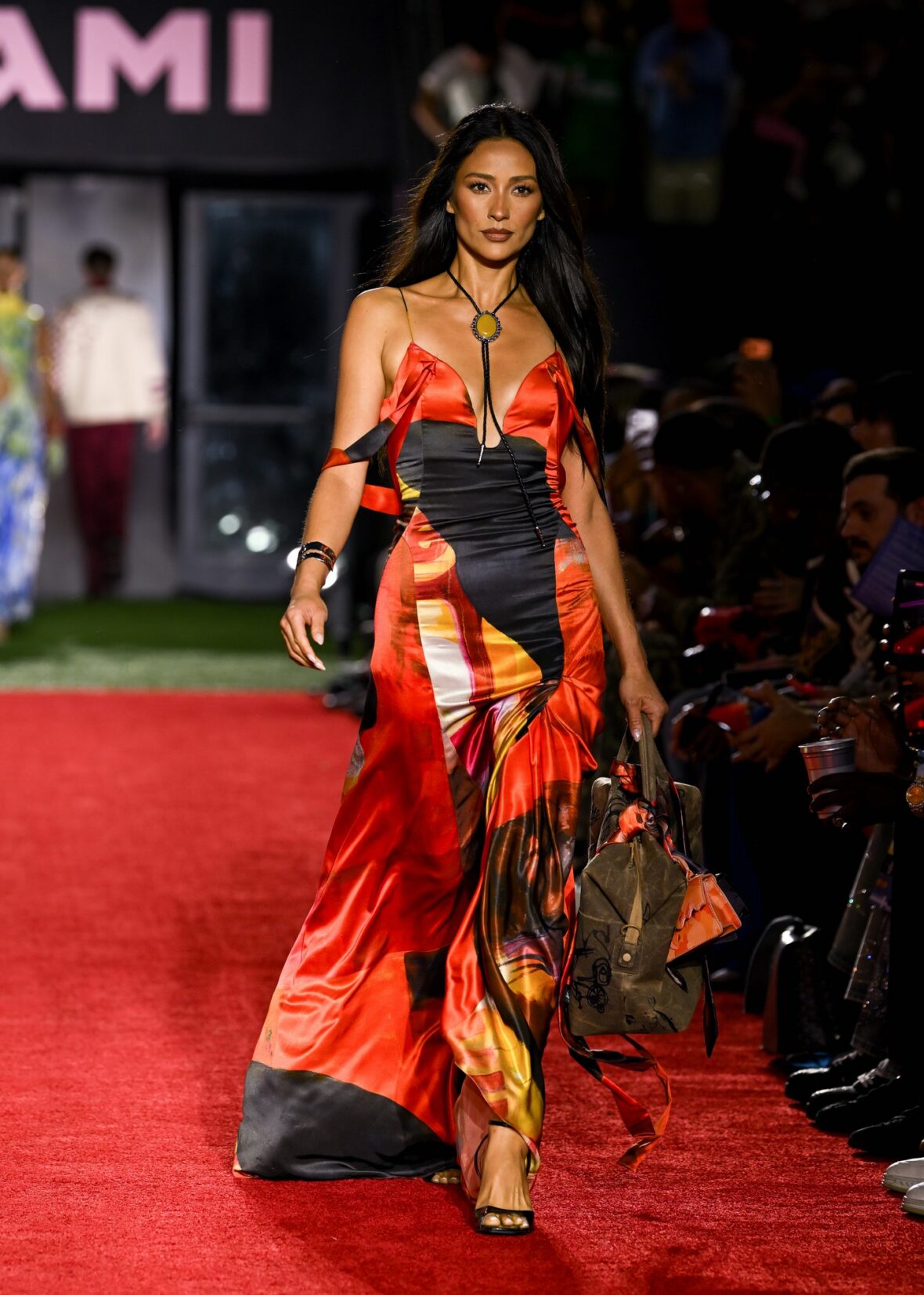 Shay Mitchell em um vestido laranja nos bastidores