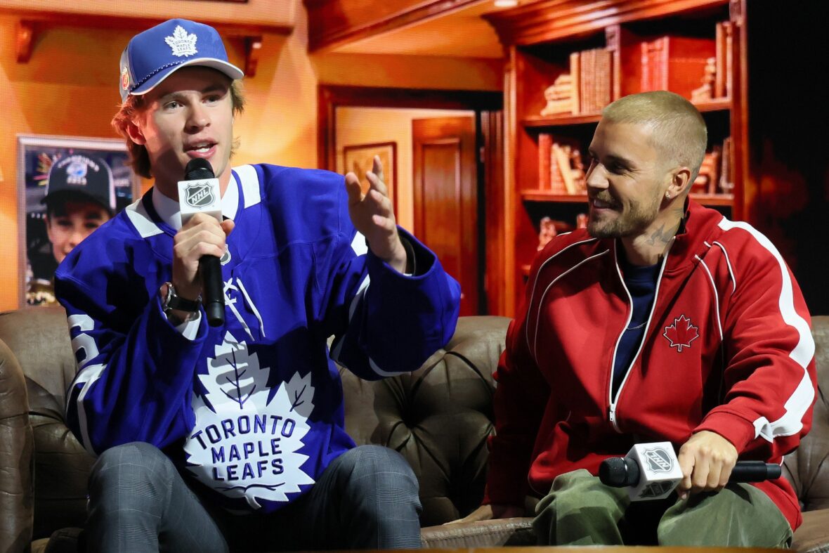 Gavin McKenna, do Canadá, e o cantor Justin Bieber observam depois que McKenna foi convocado pelo Toronto Maple Leafs