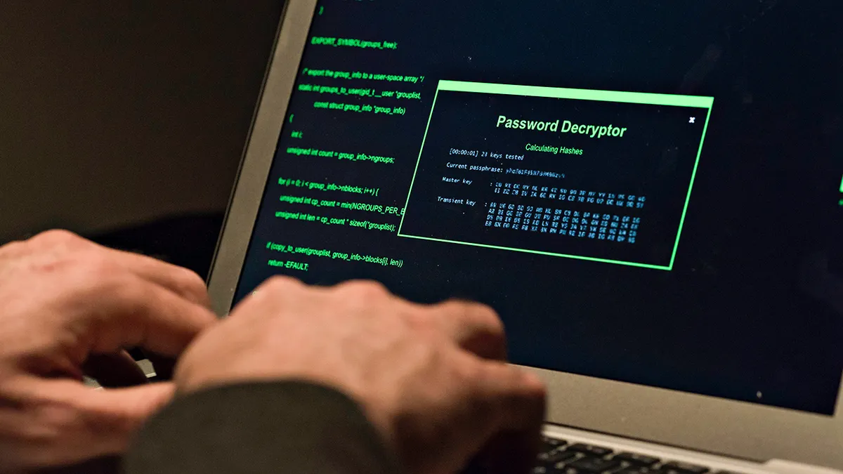 Hacker typing on a laptop.
