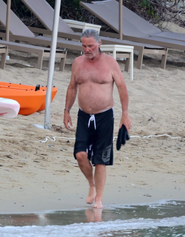 Kurt Russell sem camisa na praia.